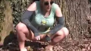 Girl piss behind a tree
