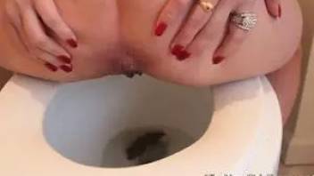 The girl shit in a toilet bowl. Close-up