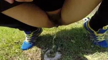 Girl in sneakers pissing on the grass