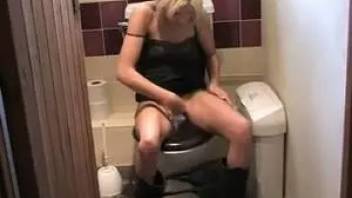 Skinny blonde pissing in toilet