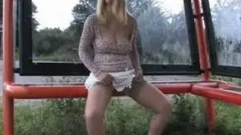 Drunk girl pissing at the bus stop and shows tits