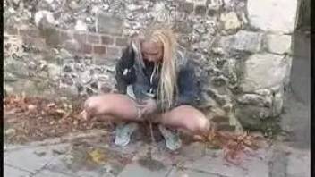Blonde pissing on the street during the day