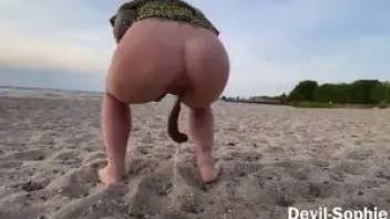 Blonde pooping on a public beach